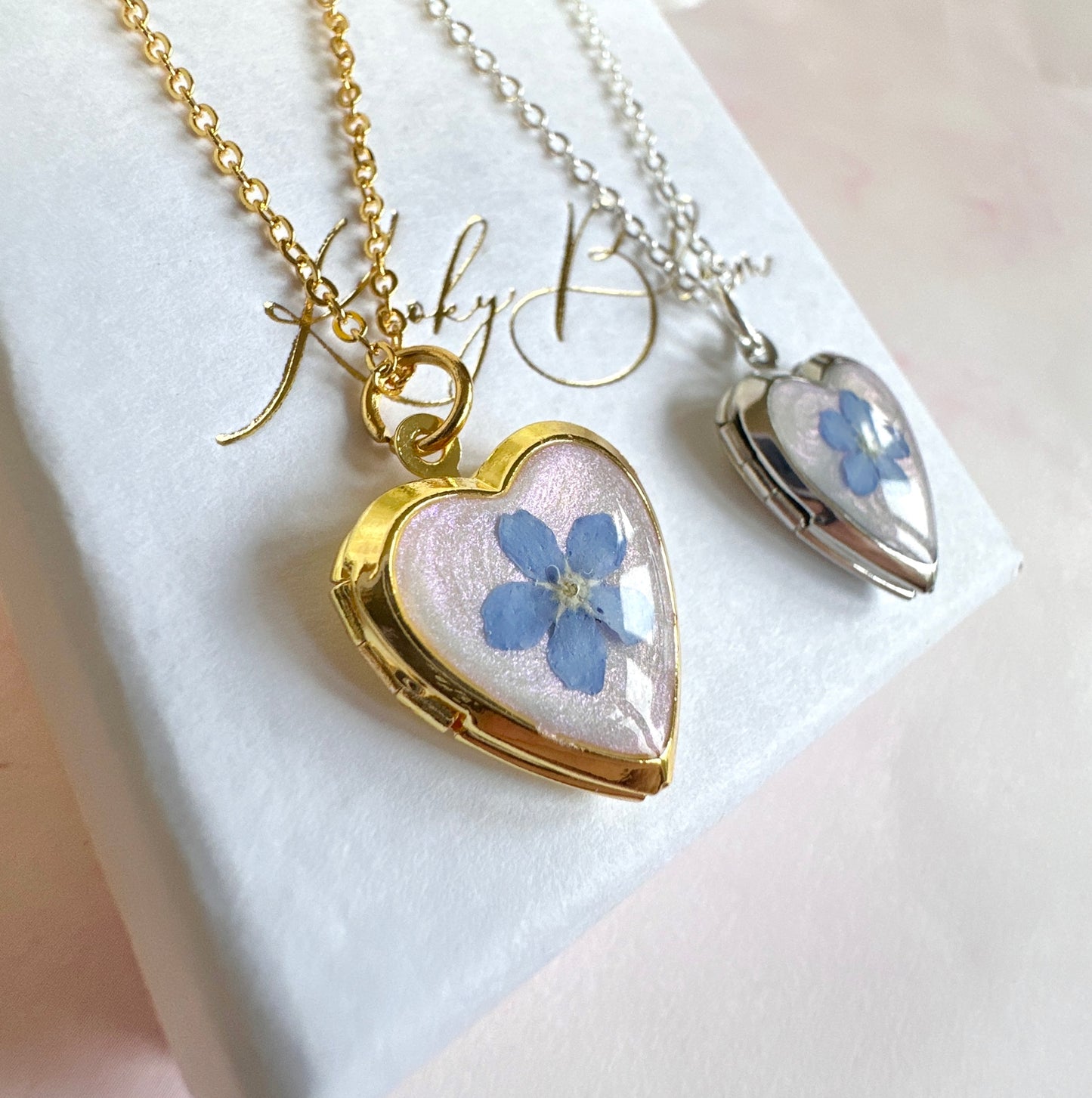 Gold forget me not flower heart locket necklace.