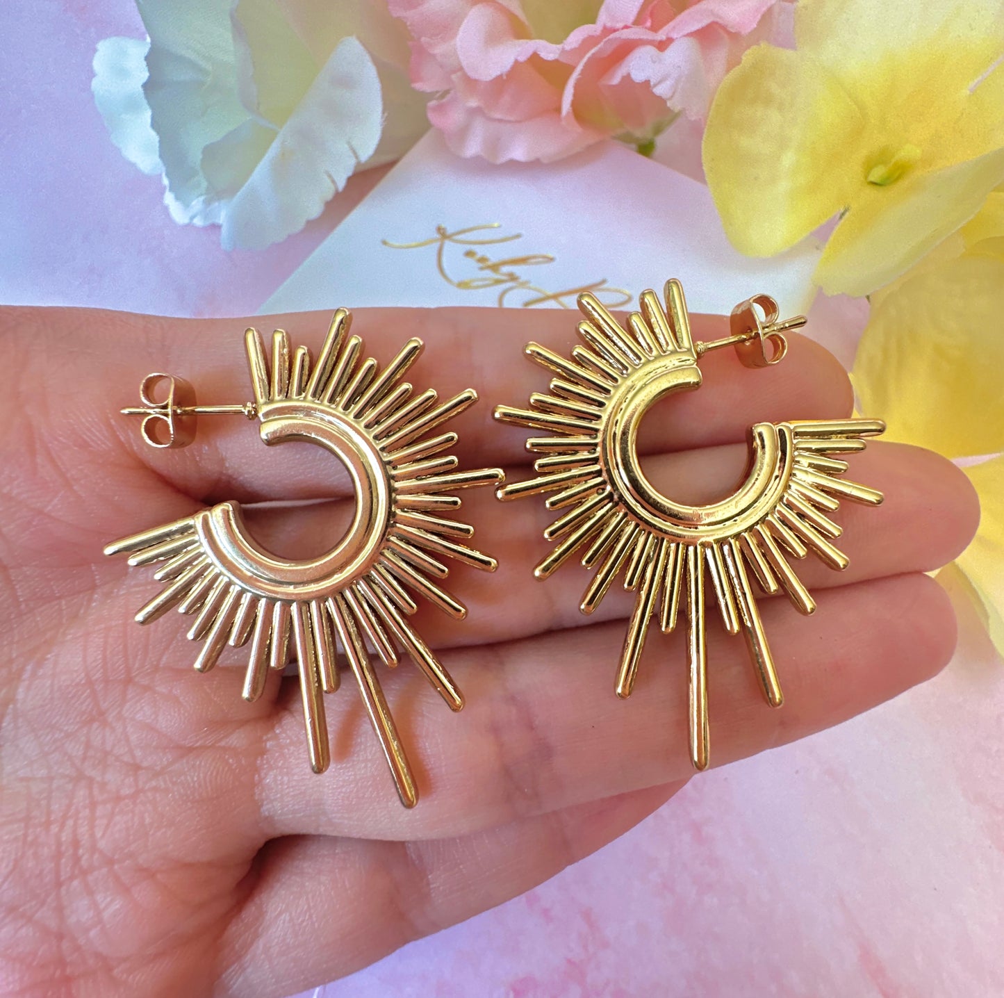 Gold Sun-ray stud earrings.