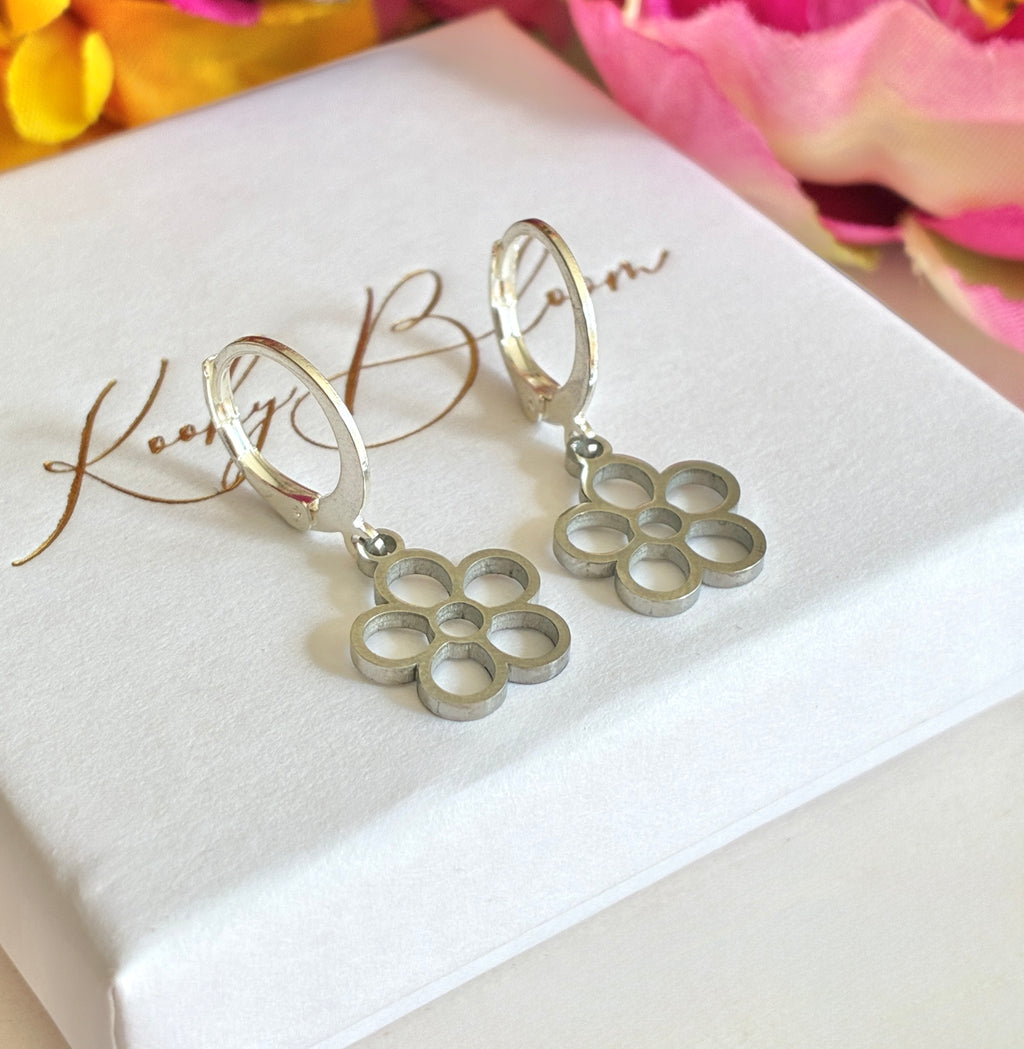 Silver tiny hollow flower huggie earrings.