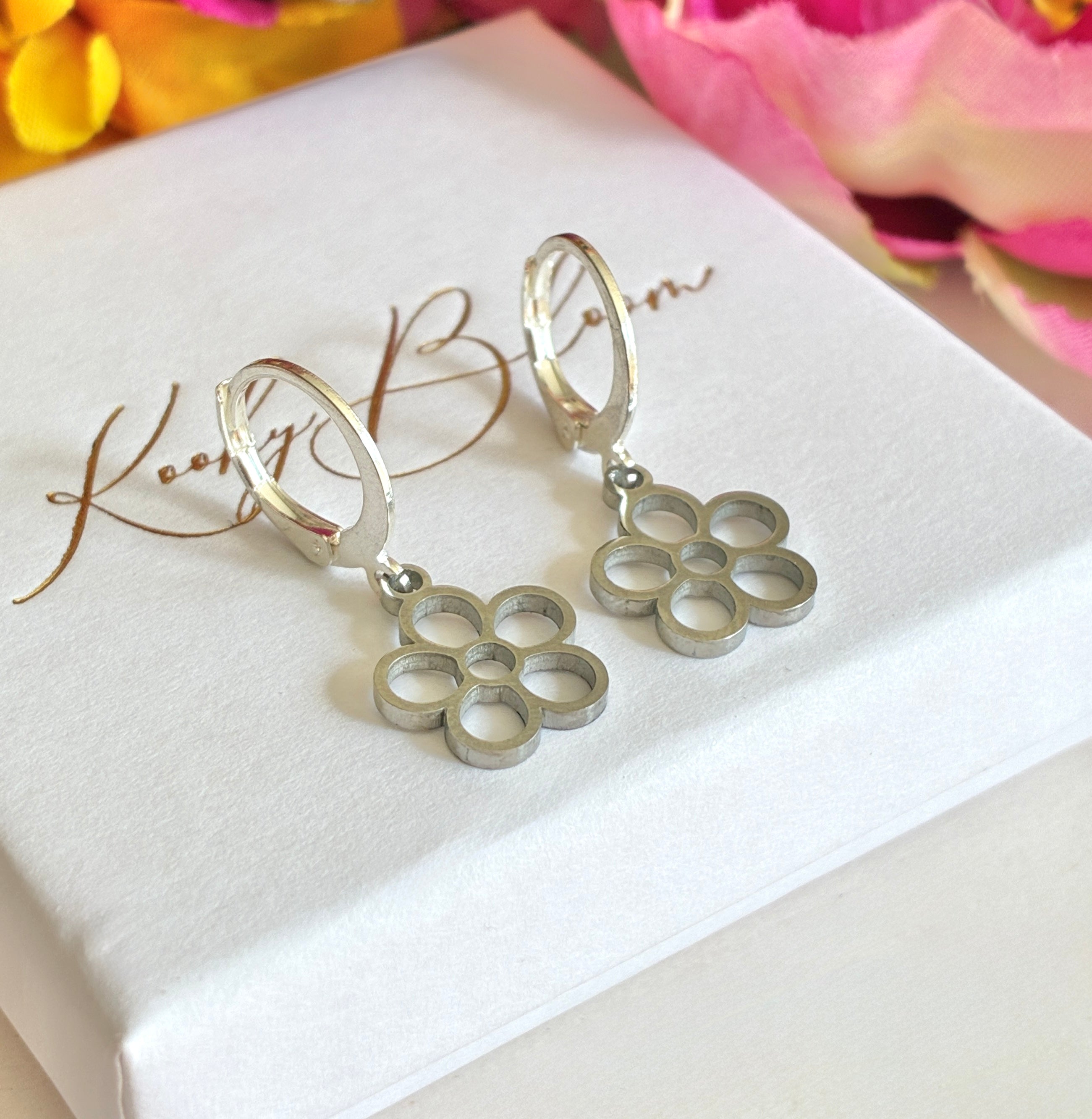 Silver tiny hollow flower huggie earrings.