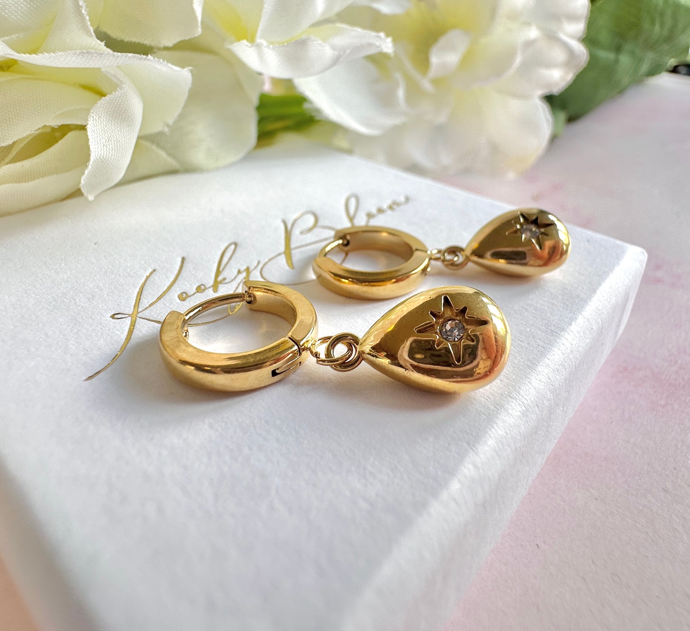 Gold teardrop cz huggie hoop earrings.