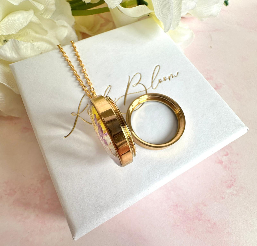 Gold real flower capsule locket necklace.