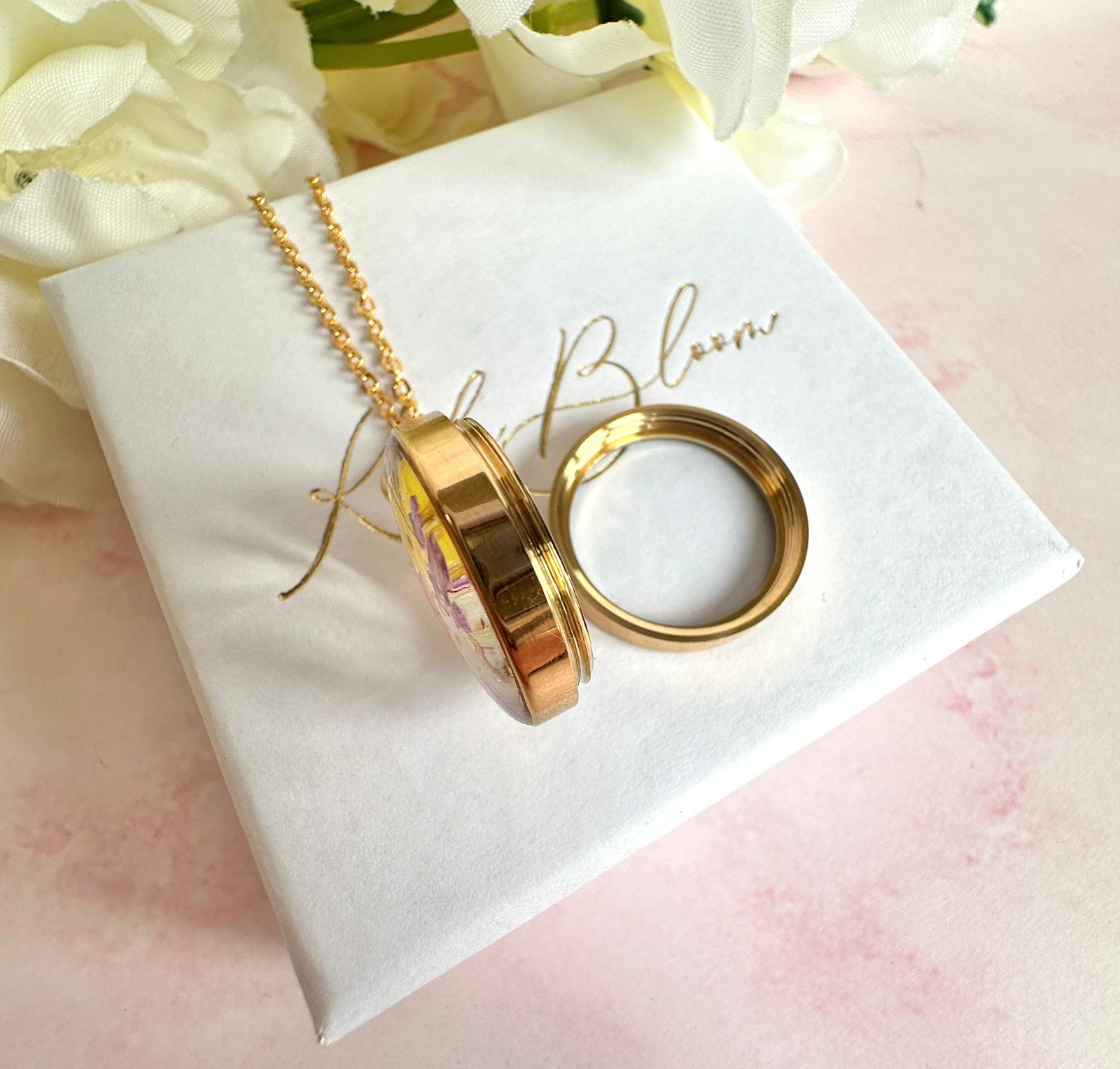 Gold real flower capsule locket necklace.