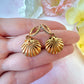 Gold seashell CZ huggie earrings.
