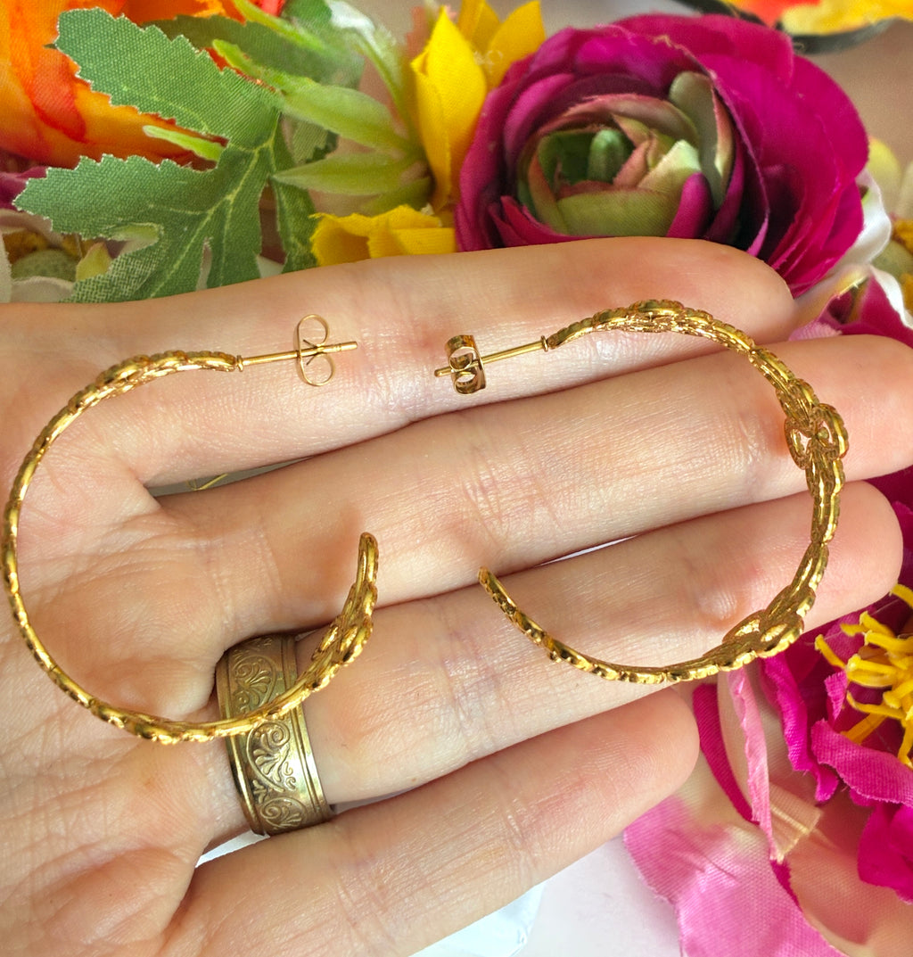 Gold floral pattern hoop earrings.