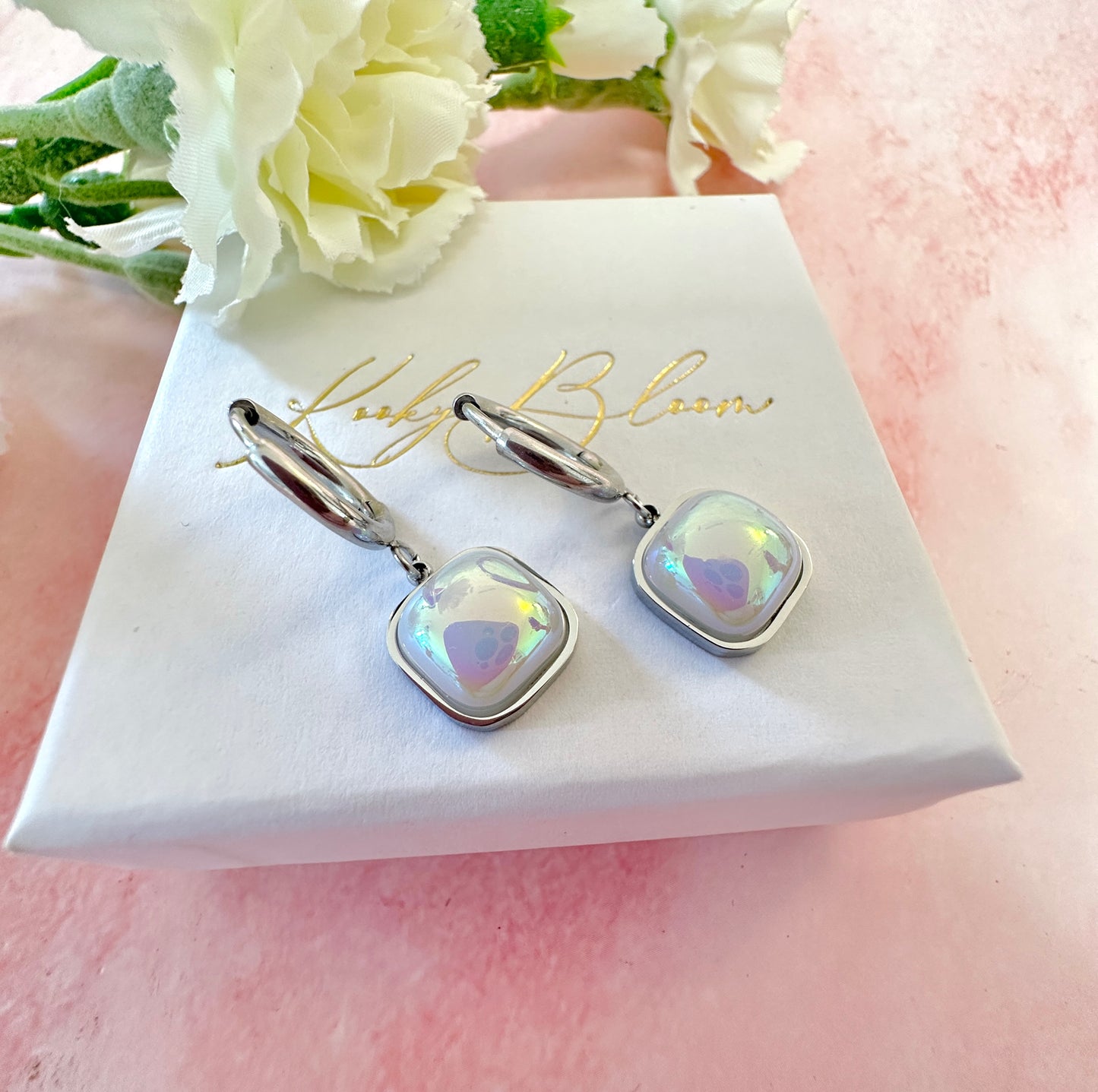 Silver iridescent square huggie hoop earrings.