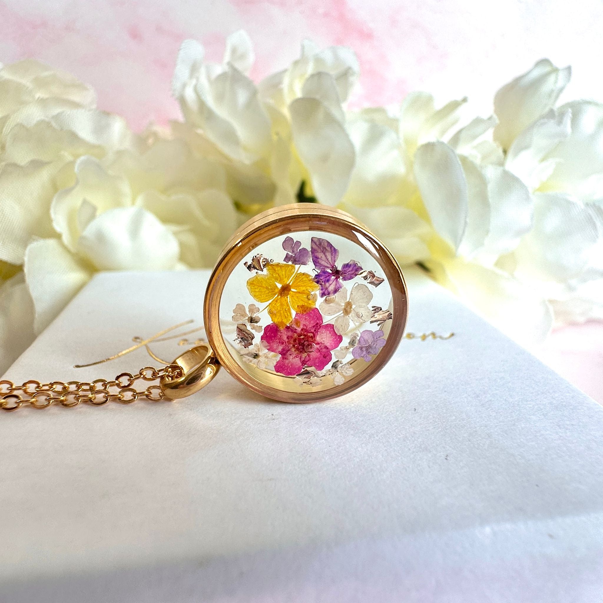 Gold real flower capsule locket necklace.