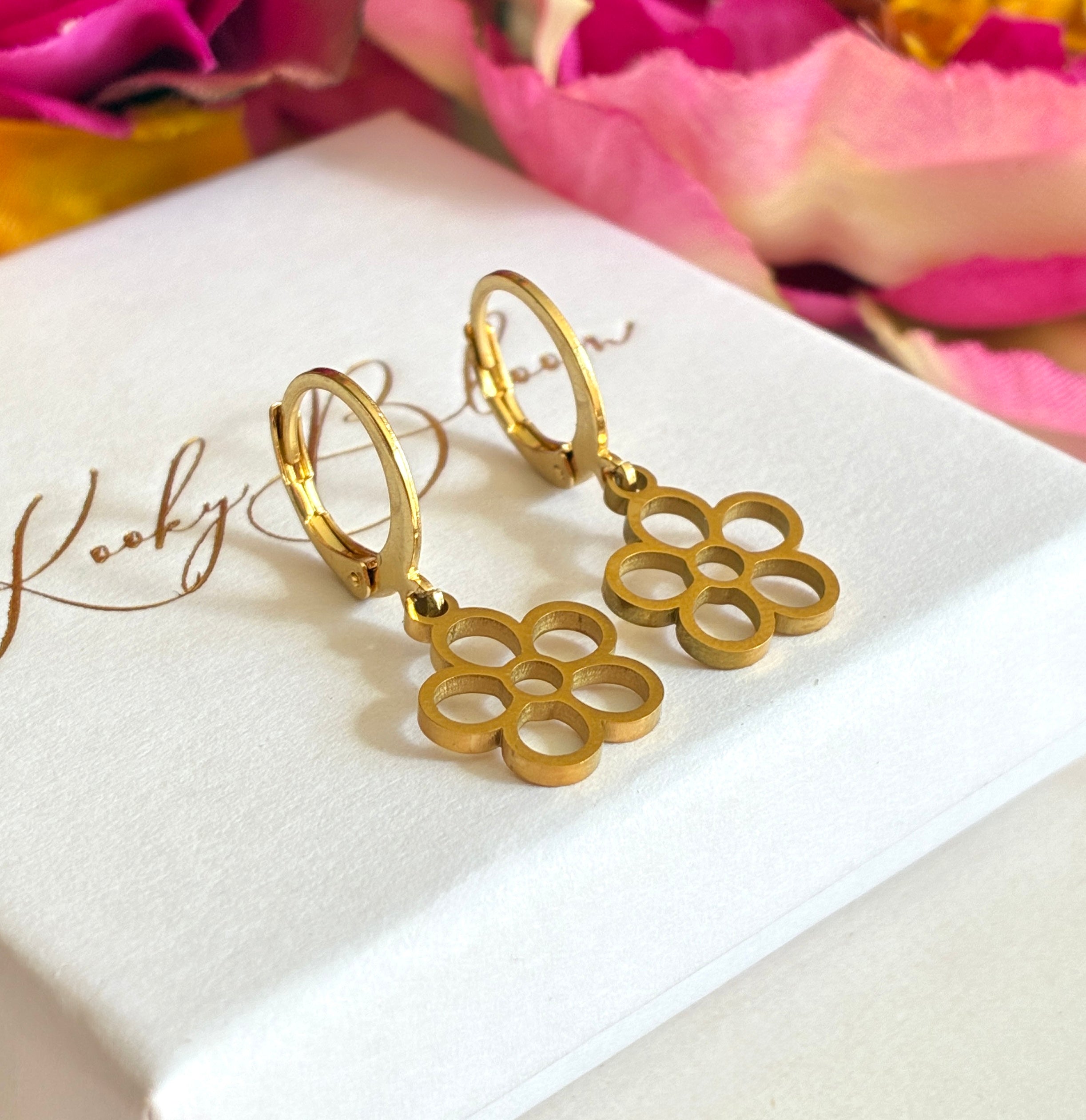 Gold tiny hollow flower huggie earrings.