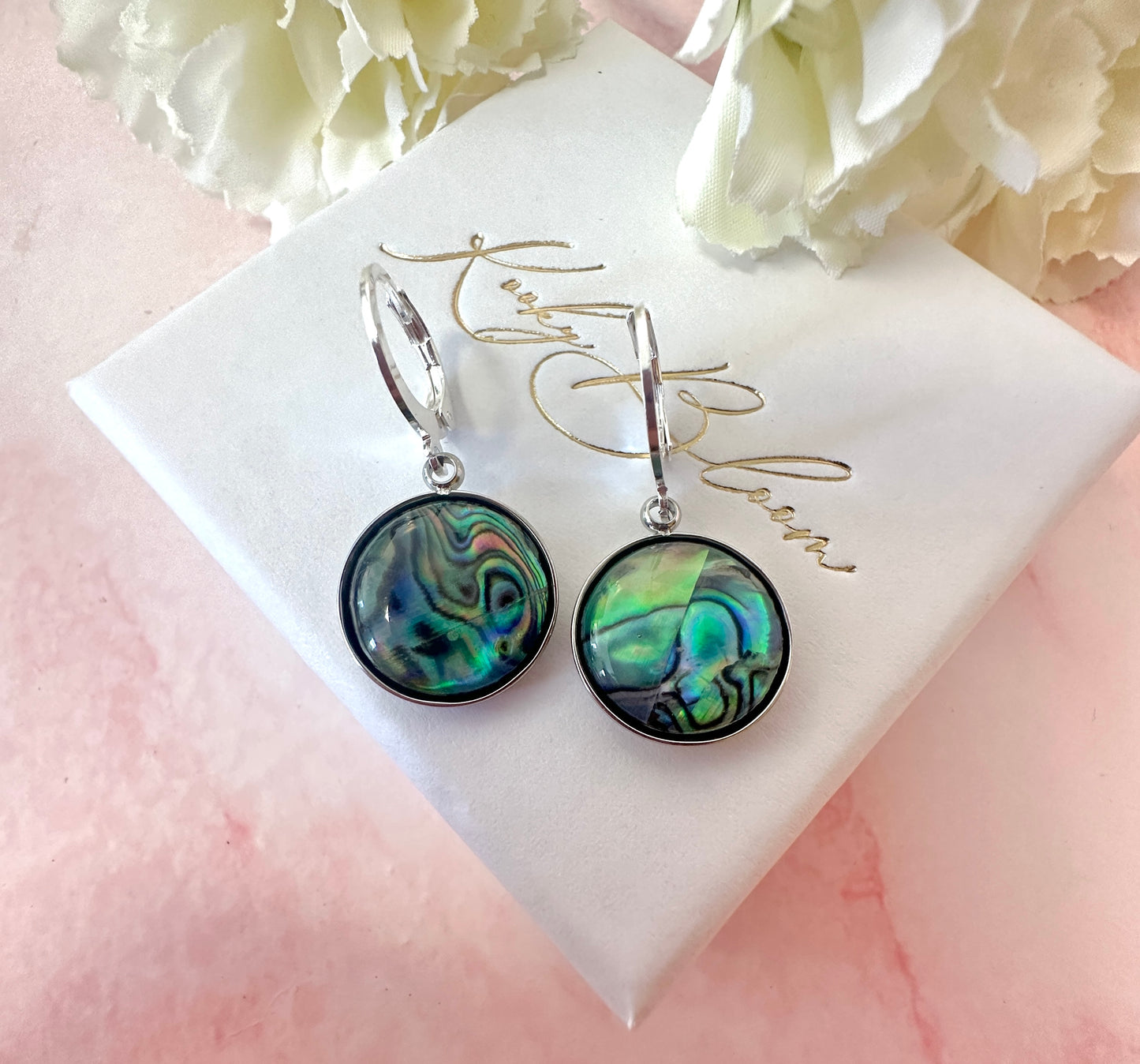 Silver Shell disc huggie earrings.