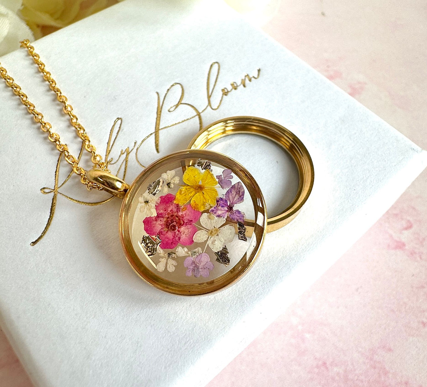 Gold real flower capsule locket necklace.