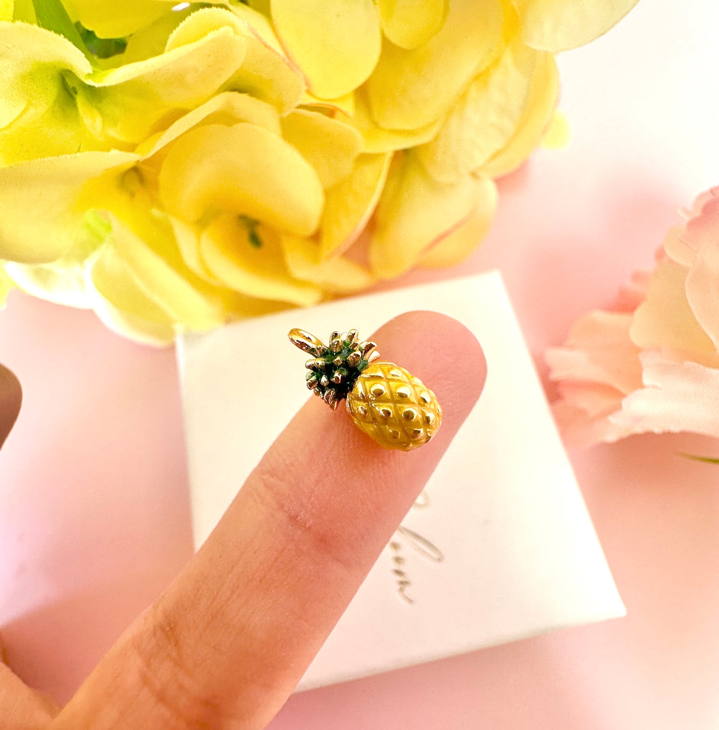Tiny enamel pineapple gold huggie earrings.