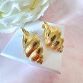 Gold oversized Seashell stud earrings.