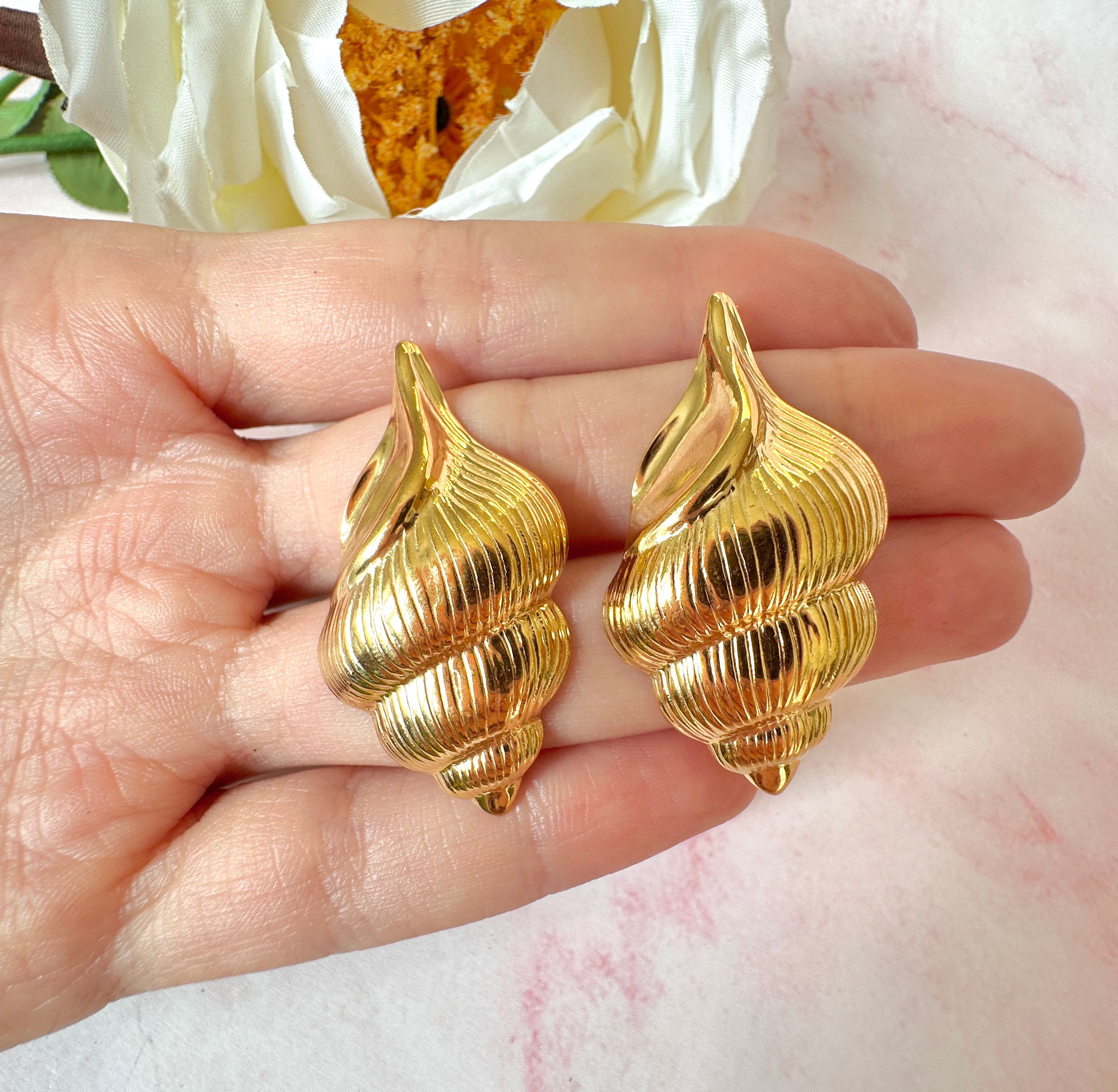 Gold oversized Seashell stud earrings.