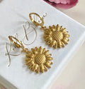 Gold sunflower huggie earrings.
