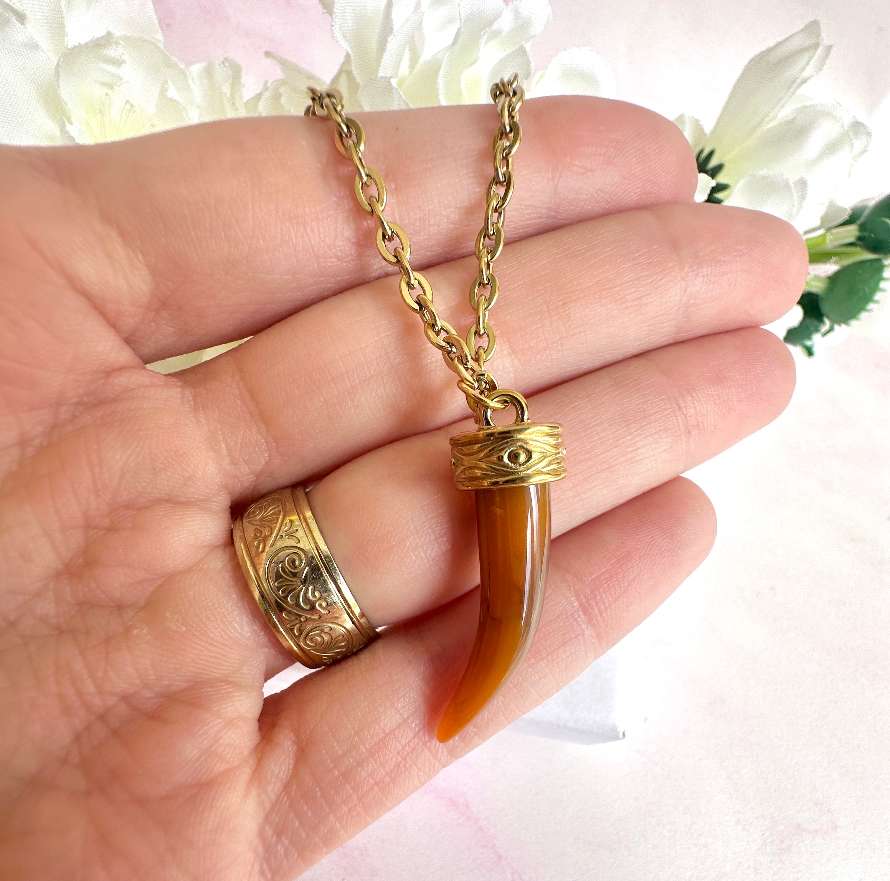 Gold tan Tusk necklace.