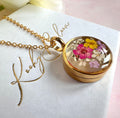 Gold real flower capsule locket necklace.