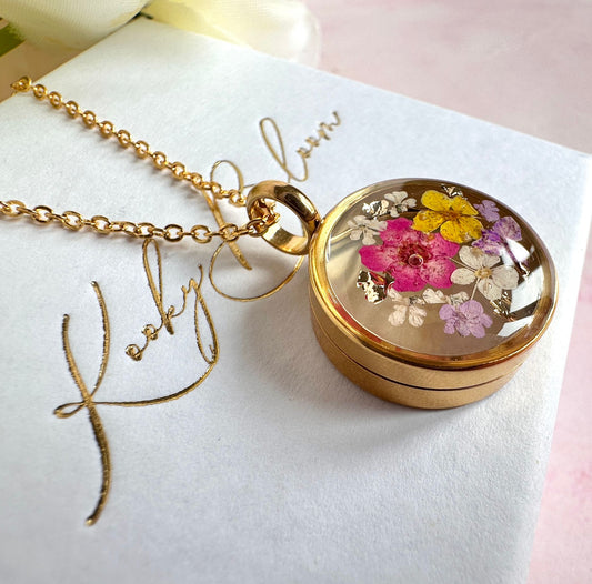 Gold real flower capsule locket necklace.