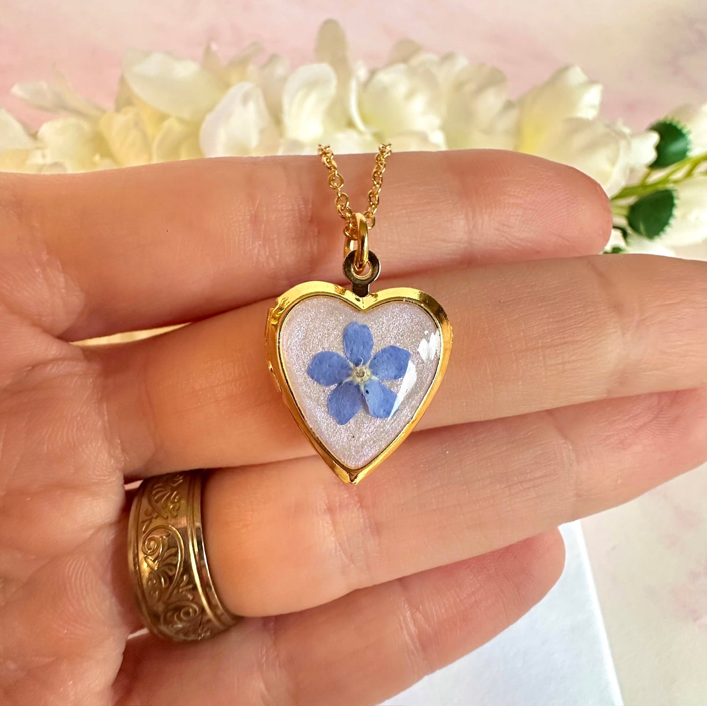 Gold forget me not flower heart locket necklace.
