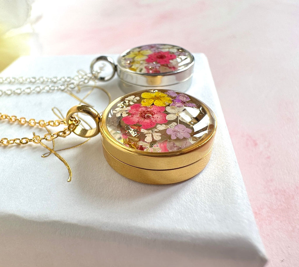 Gold real flower capsule locket necklace.