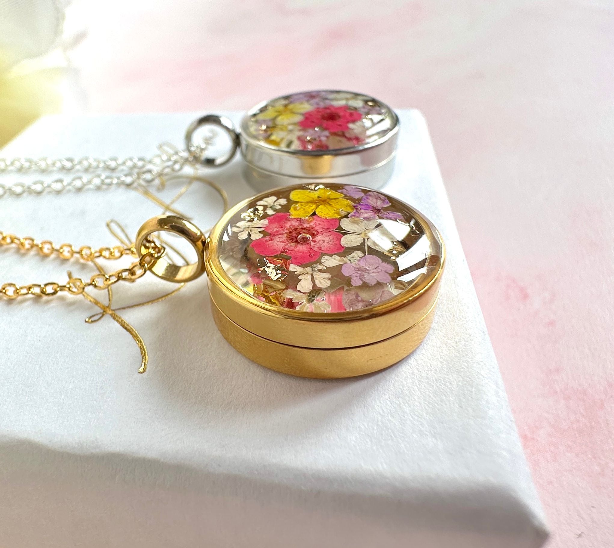 Gold real flower capsule locket necklace.