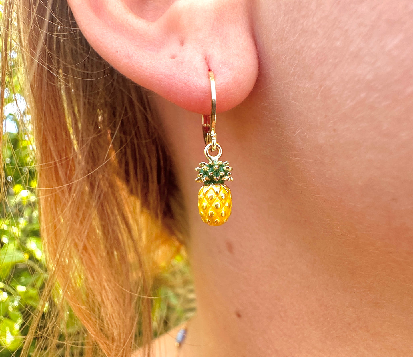 Tiny enamel pineapple gold huggie earrings.