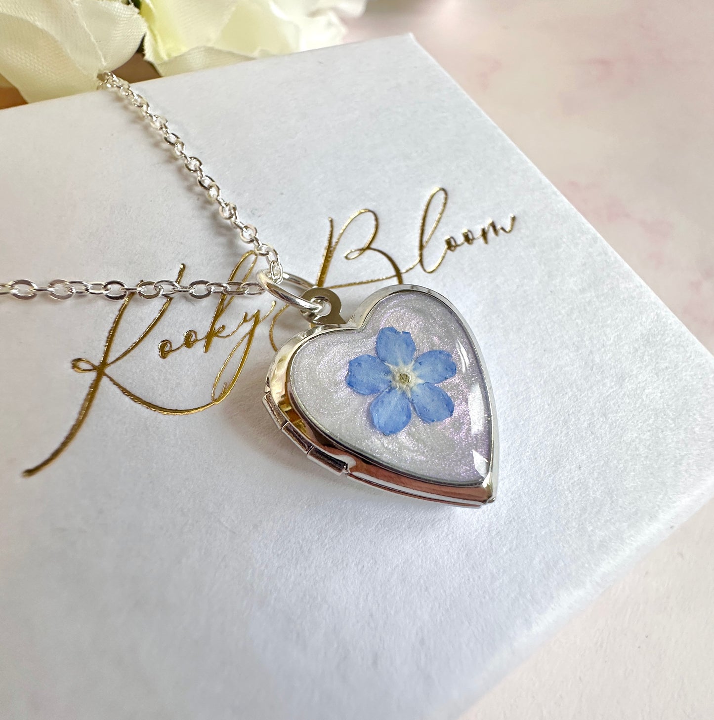 Silver Forget me not flower heart locket necklace.