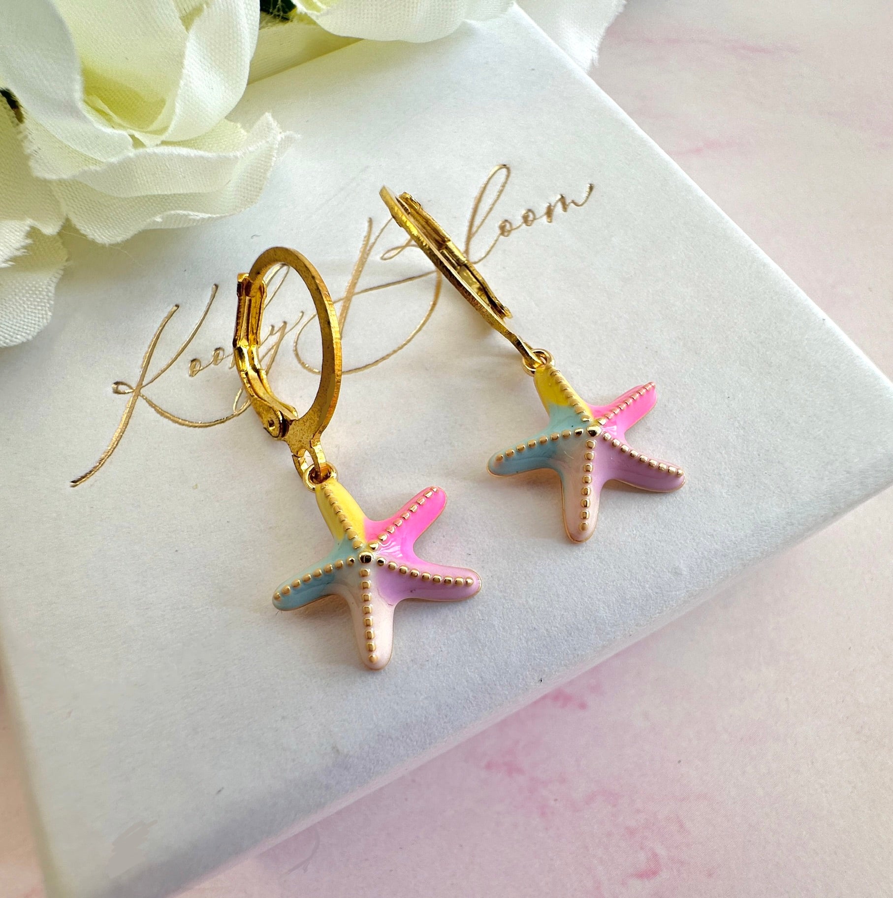Gold colourful starfish huggie earrings.