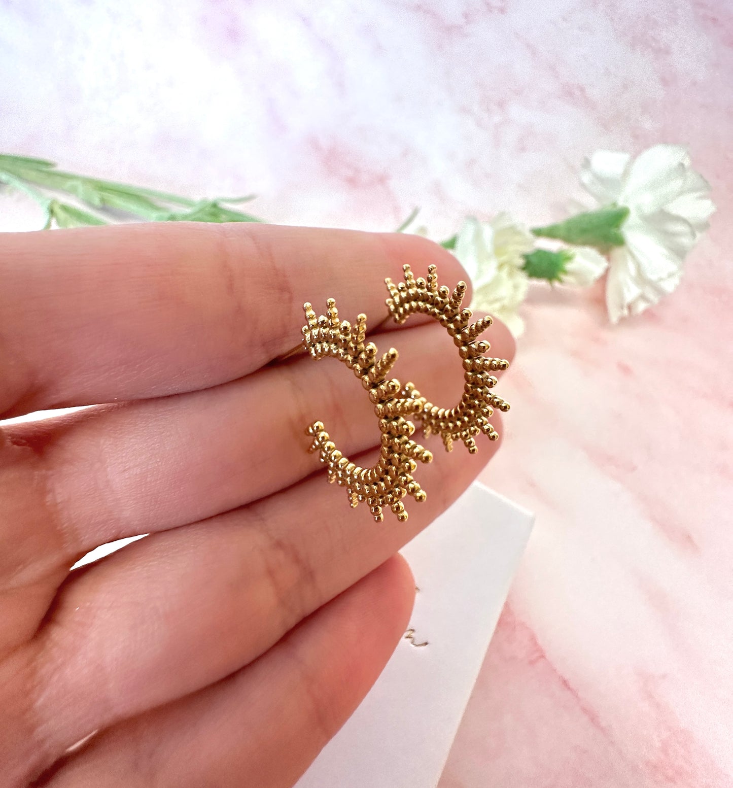 Gold sun ray earrings.