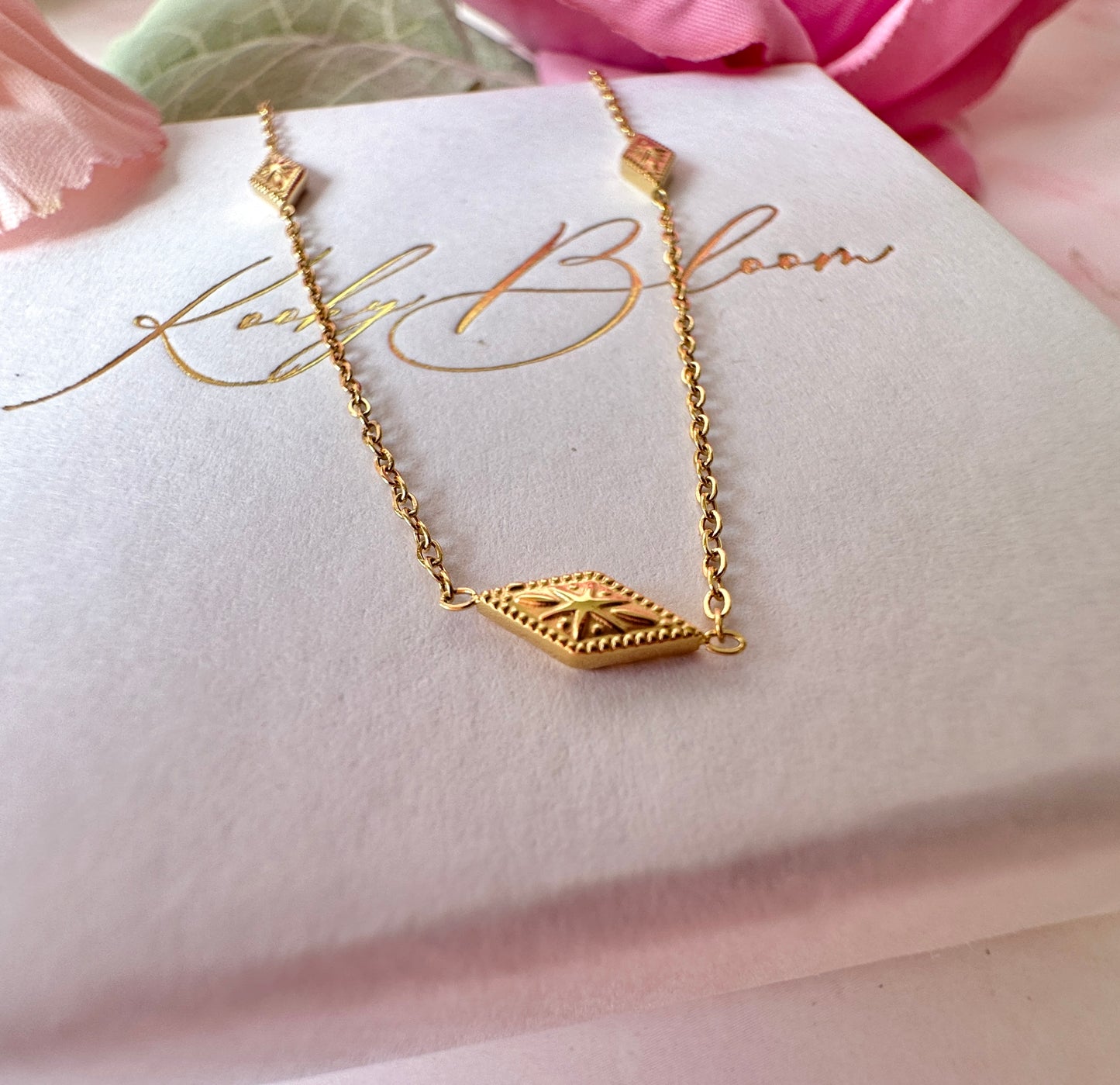 Gold dainty engraved star diamond necklace.