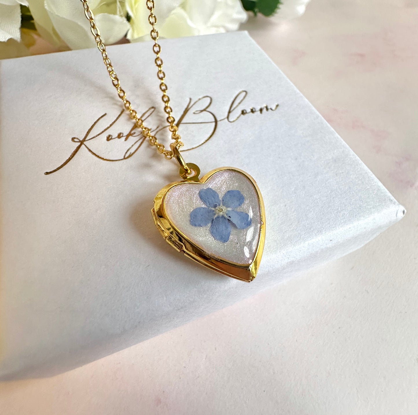 Gold forget me not flower heart locket necklace.