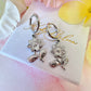 Silver flower drop hoop earrings.