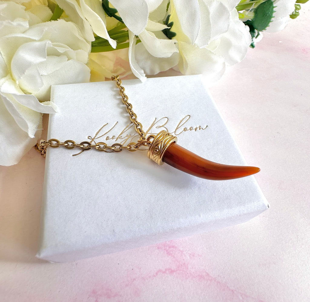 Gold tan Tusk necklace.