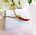 Gold tan Tusk necklace.