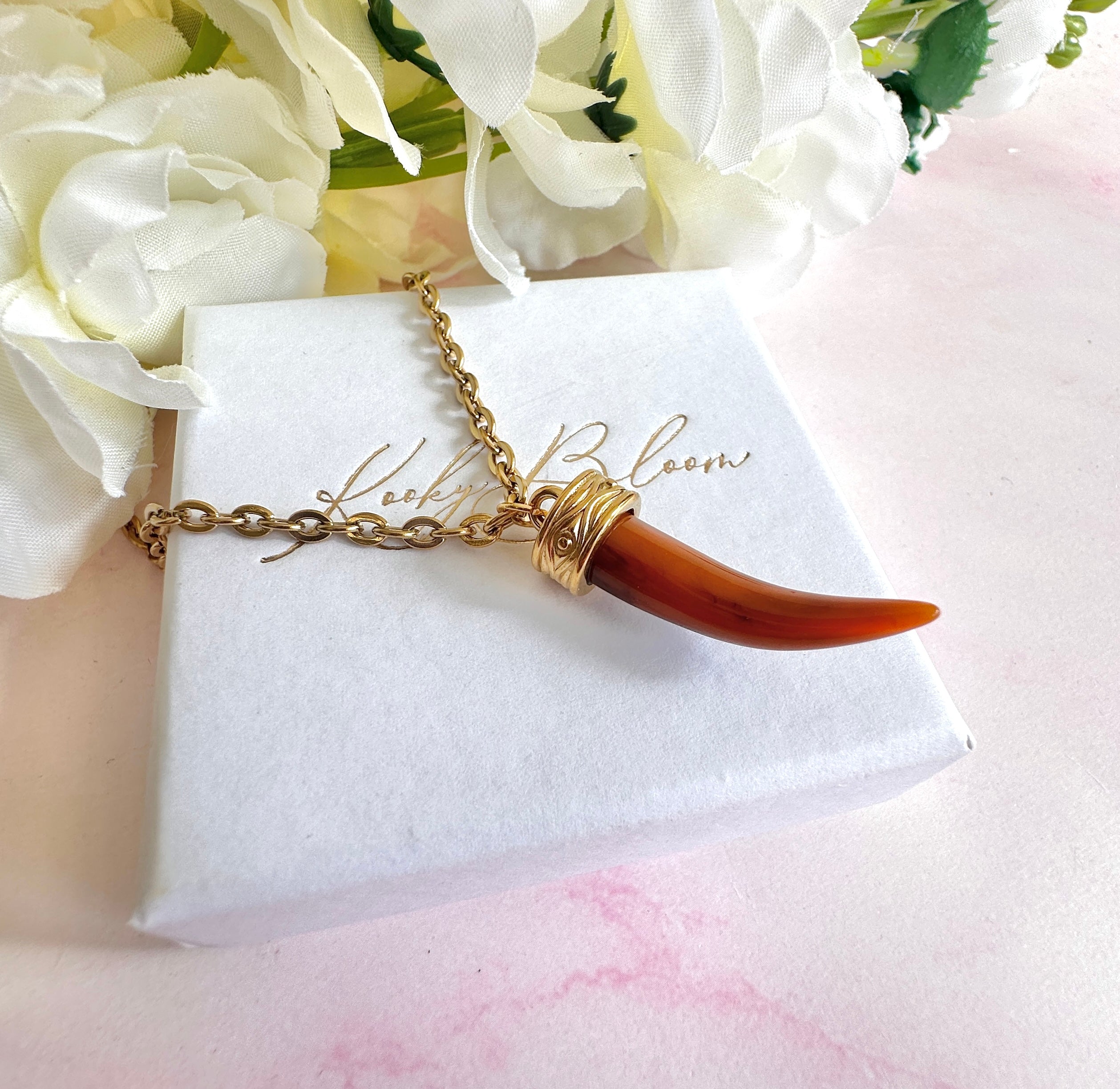 Gold tan Tusk necklace.