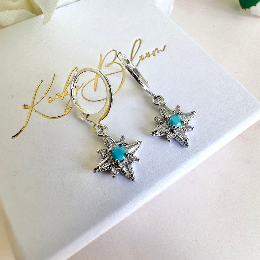 Silver tiny Cz Blue stone Star huggie earrings.