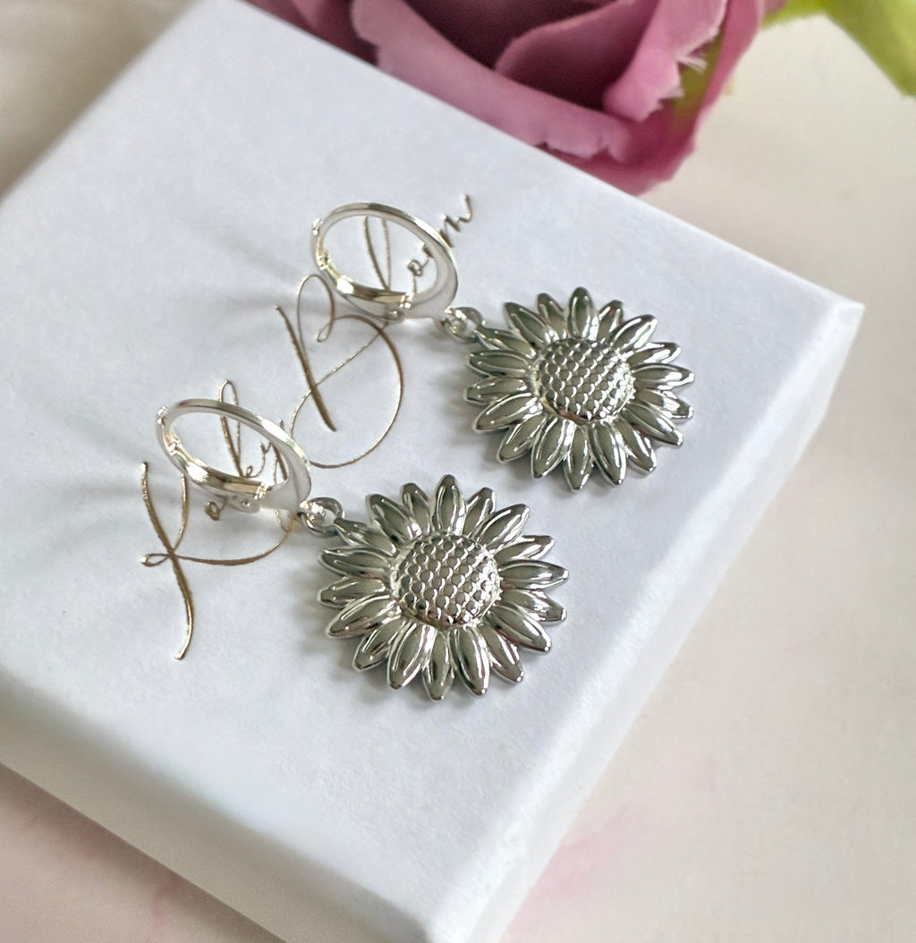 Silver Sunflower huggie earrings.