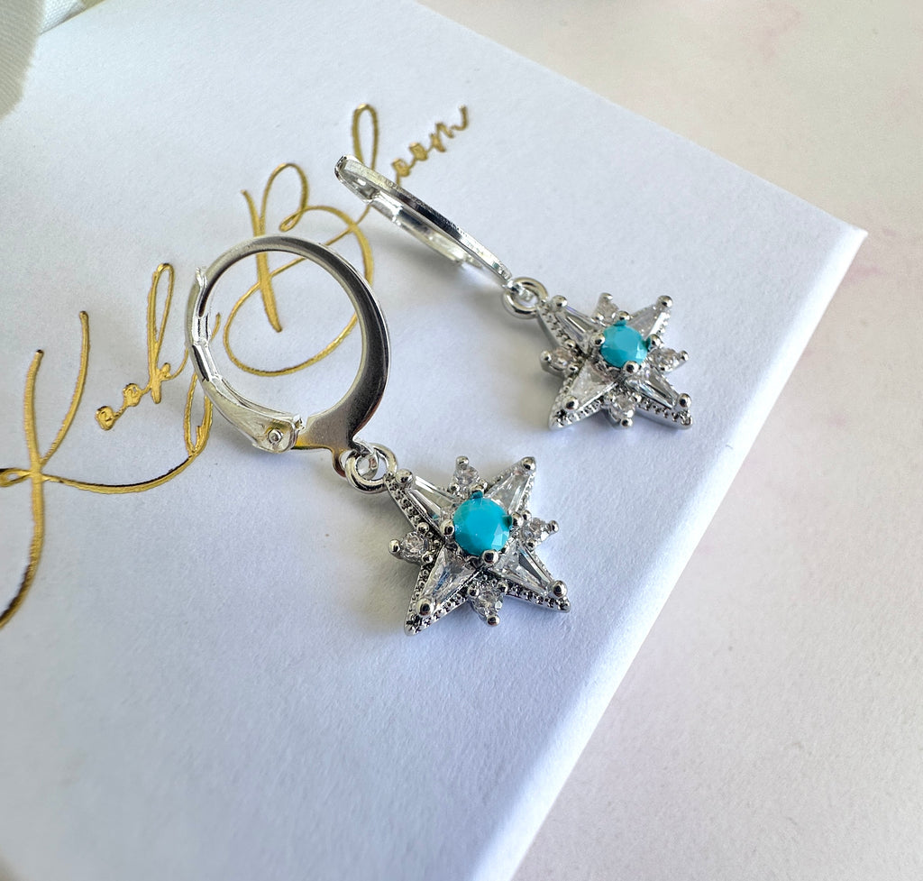 Silver tiny Cz Blue stone Star huggie earrings.