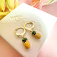 Tiny enamel pineapple gold huggie earrings.