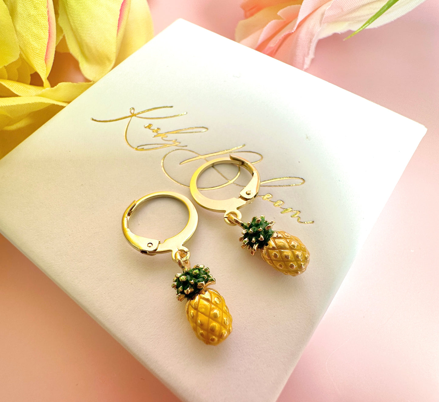 Tiny enamel pineapple gold huggie earrings.