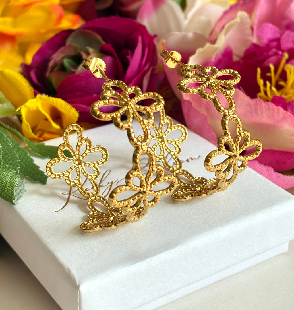Gold floral pattern hoop earrings.