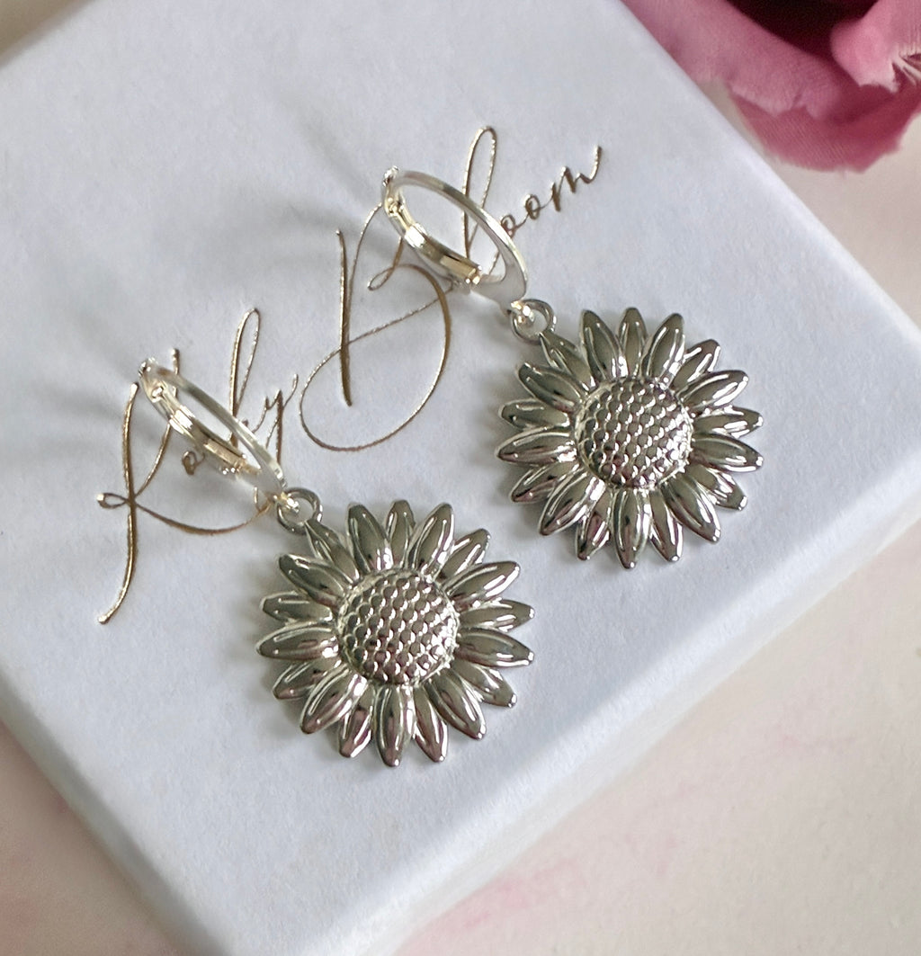 Silver Sunflower huggie earrings.