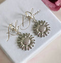 Silver Sunflower huggie earrings.
